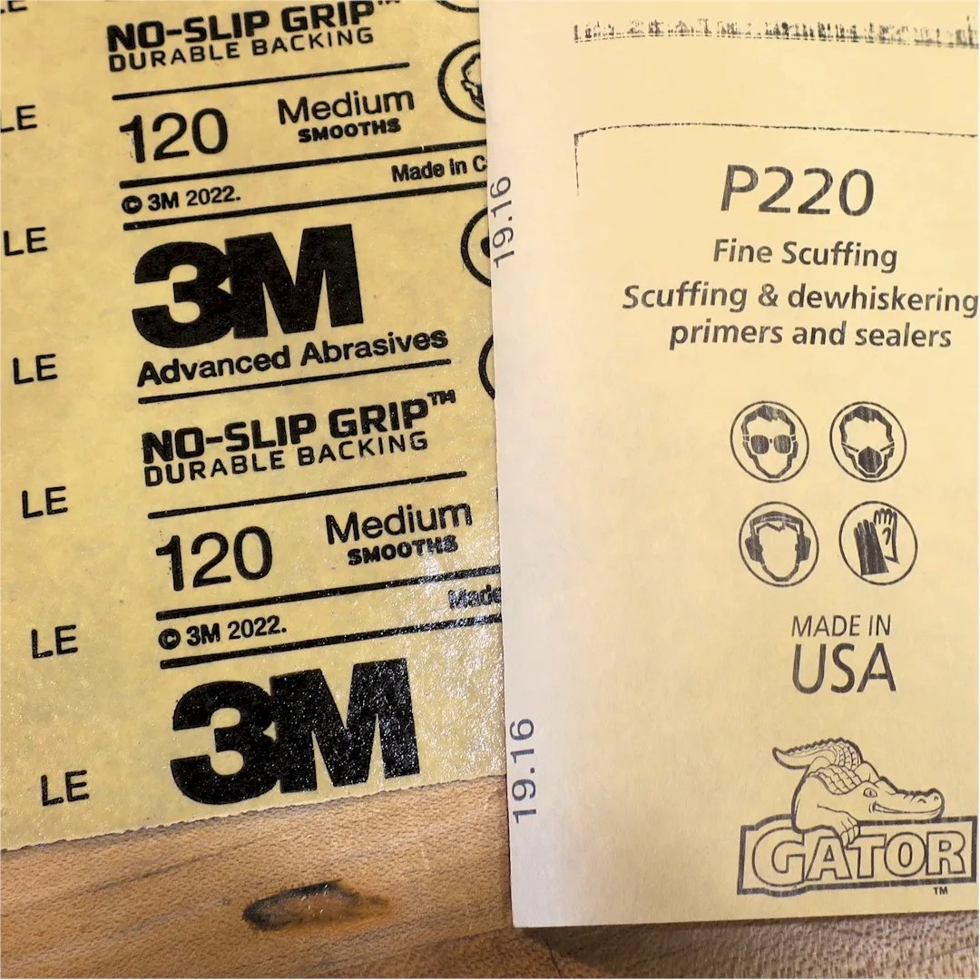 Photo of the back of sheets of sandpaper showing the the labeled grit size